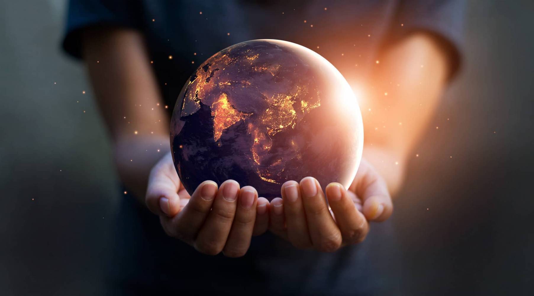 hands holding sunlit earth globe