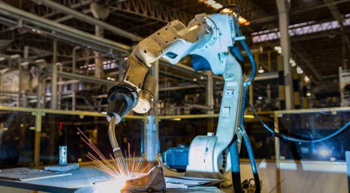 Photo of automated robotic manufacturing equipment welding a product in a factory